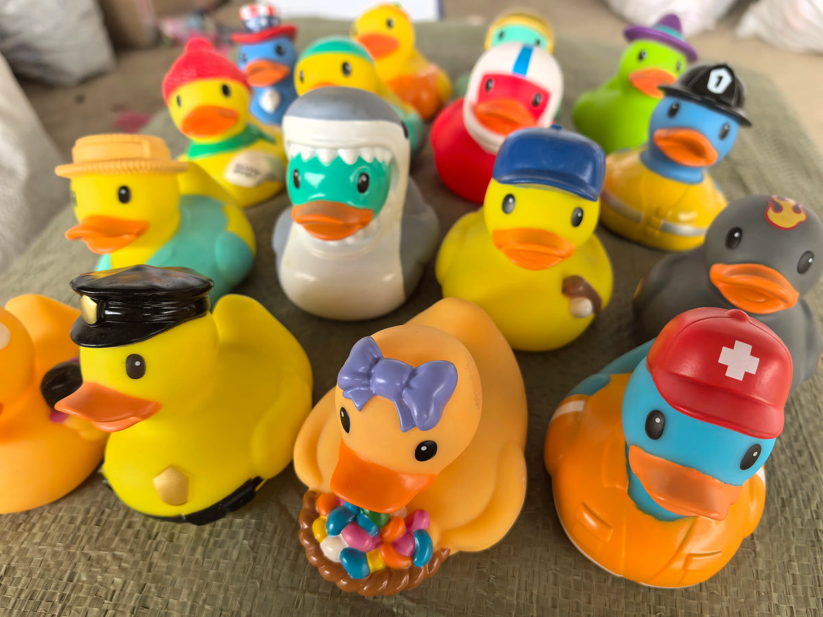 A collection of yellow and orange rubber duck bath toys scattered on a surface.