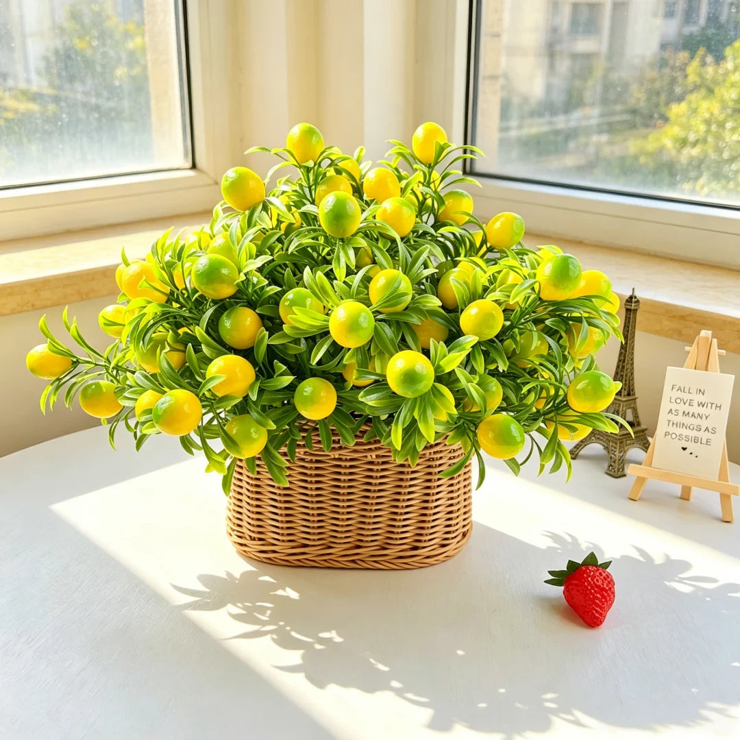 A potted arrangement of bright yellow-green lemon branches with leaves on a white table near a window.