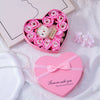 Pink heart-shaped gift box filled with artificial roses and a white plush bear