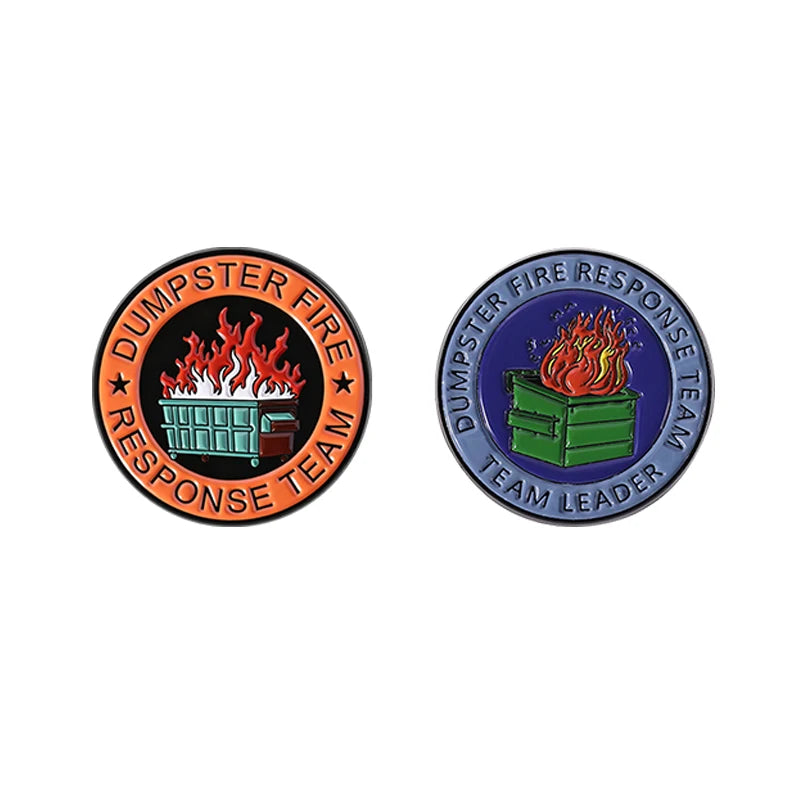 An enamel pin featuring a dumpster fire rescue team design with flames and a green dumpster.
