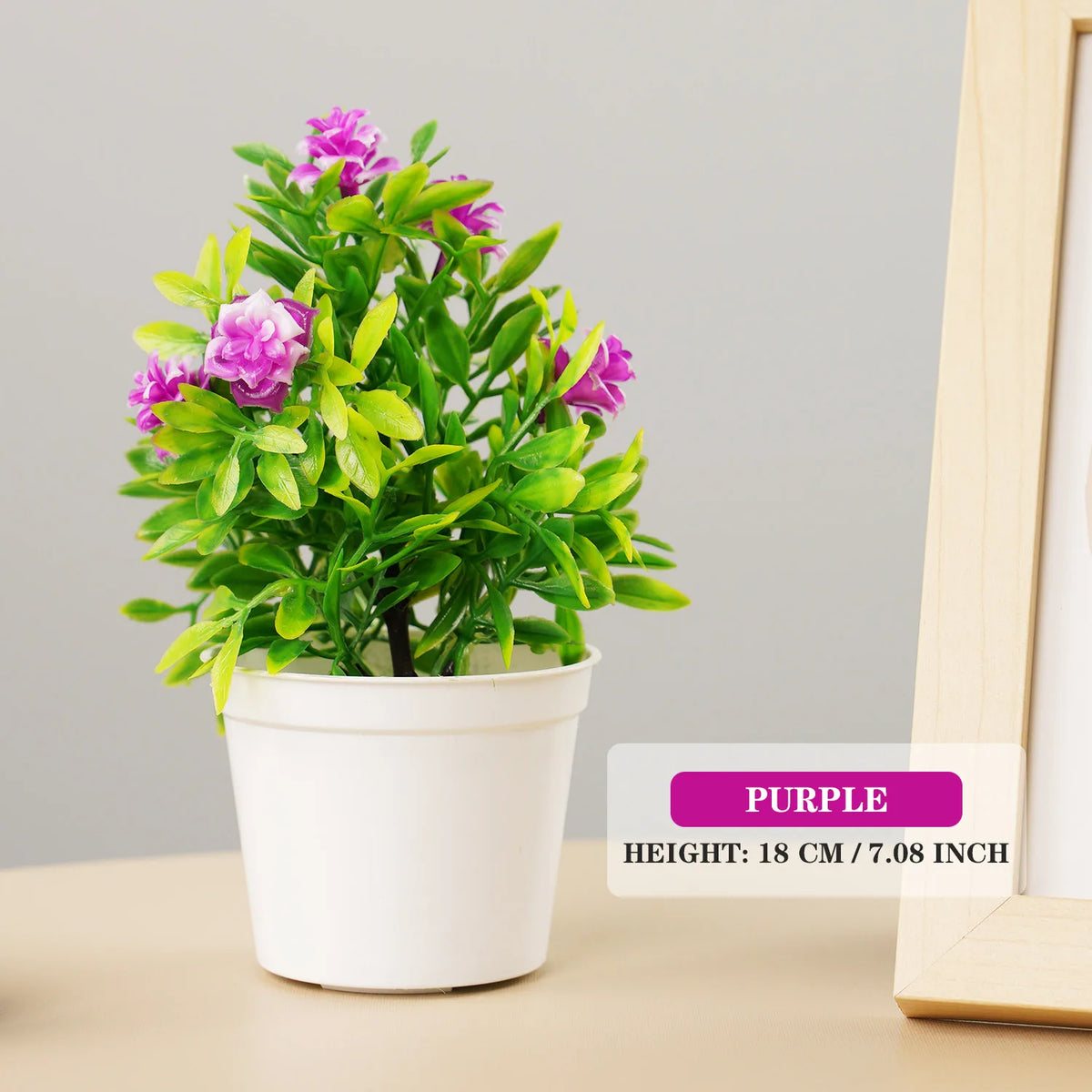 Artificial purple bonsai tree in a white pot with bright green leaves