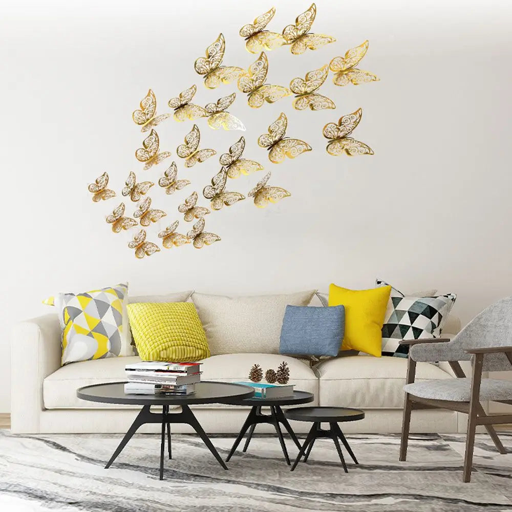A set of 3D hollow butterfly wall decals in gold and white fluttering on a white wall above a modern sofa.