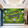 A vibrant green backdrop banner for a birthday party featuring soccer balls, trophies, and crowns.