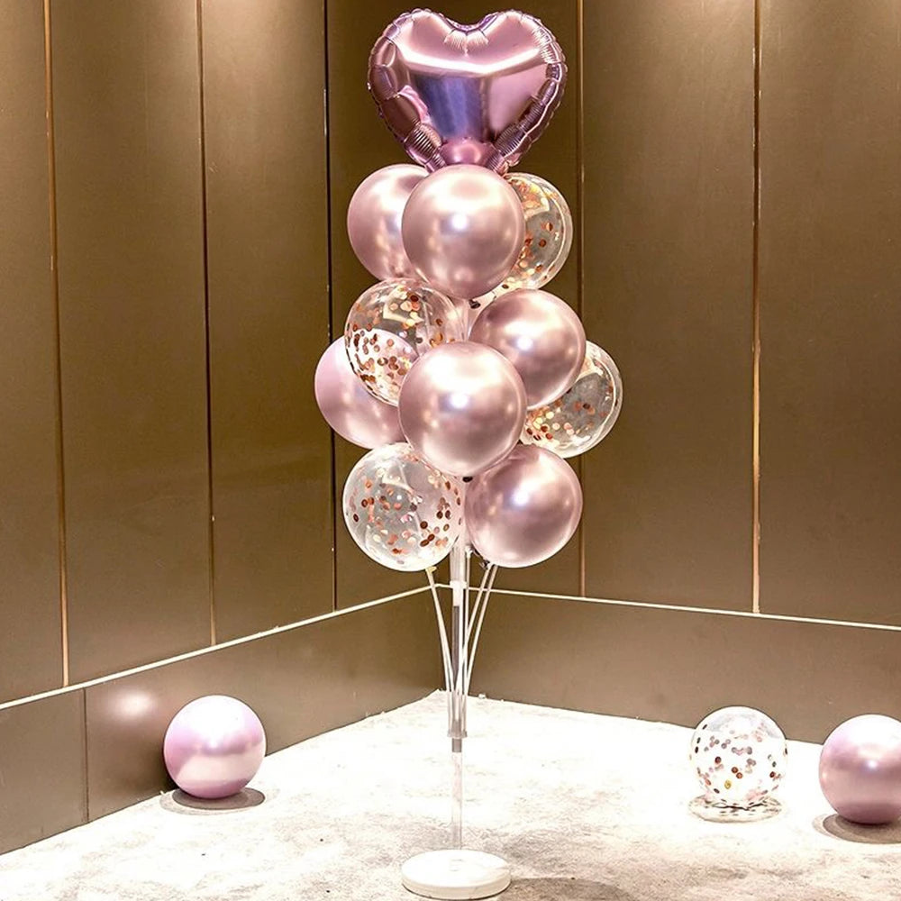 A column of pink and silver balloons, including a heart-shaped balloon on top, displayed on a stand.