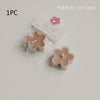A single handmade soy wax flower tea light candle in a light pink color is shown next to its packaging.