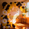 A yellow and black balloon arch set featuring bees and daisies, decorated with bright sunlight.