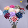 Un bouquet de petites fleurs d'hydrangea artificielles dans diverses nuances de rose, violet, bleu et vert.