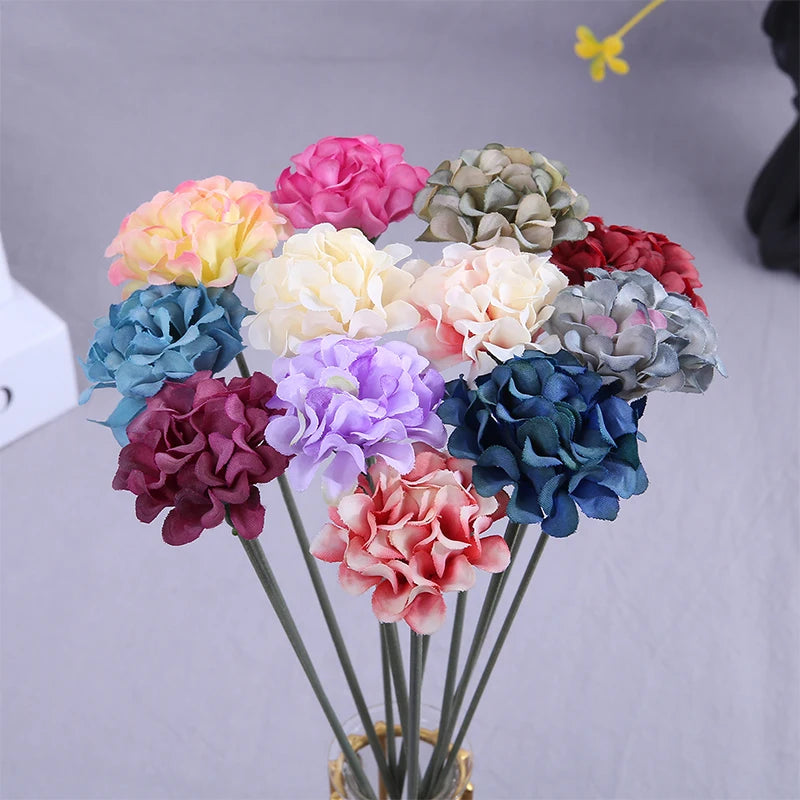 Un bouquet de petites fleurs d'hydrangea artificielles dans diverses nuances de rose, violet, bleu et vert.