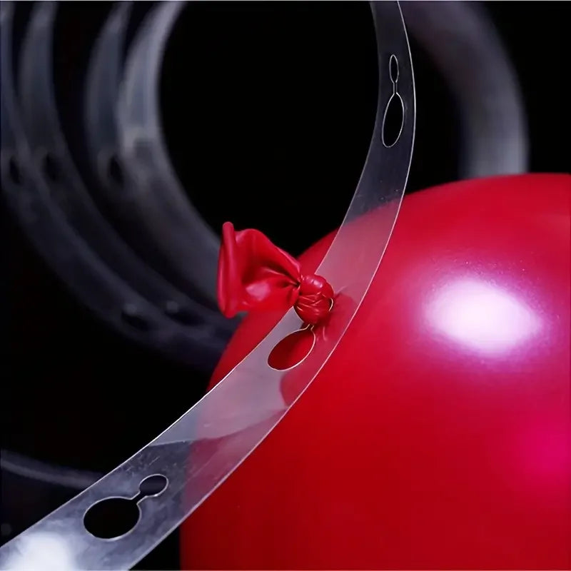 A close-up of a red balloon with a clear plastic strip and a red ribbon attached, set against a dark background.