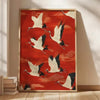 Red canvas wall art featuring white cranes in flight with gold framing.