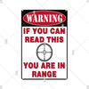 A vintage red and black warning sign with white text that reads WARNING IF YOU CAN READ THIS YOU ARE IN RANGE
