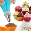 A hand holds a blue piping bag with a metal nozzle, positioned above various colorful cupcake decorations and tools.
