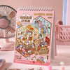 A pink sticker book titled Material Book featuring miniature scene stickers for kids, displayed next to a pink fan.