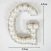 A rhinestone patch shaped like the letter G, featuring white and iridescent stones.