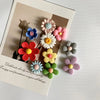 A collection of mixed color flower photo message magnets arranged on a light background.