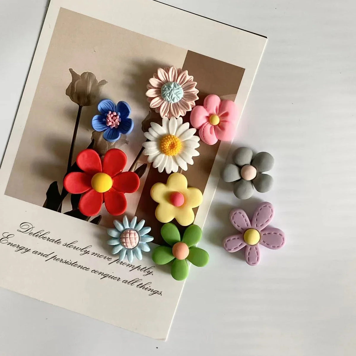 A collection of mixed color flower photo message magnets arranged on a light background.