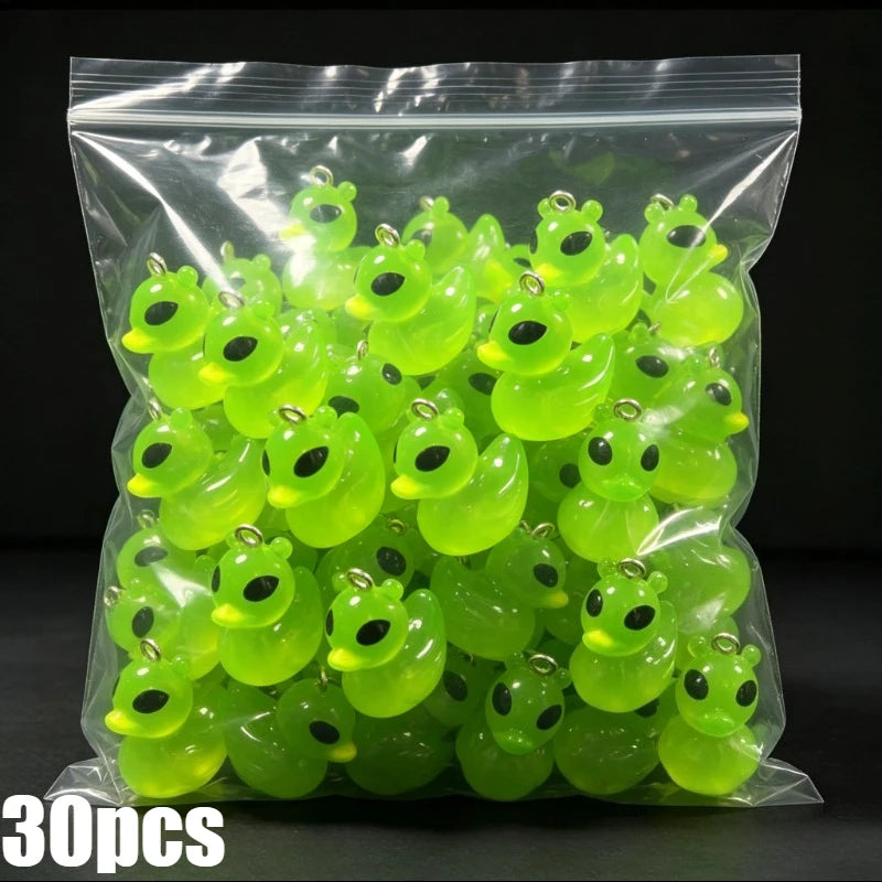 A clear plastic bag filled with thirty glow-in-the-dark resin charms shaped like alien cats and ducks.