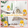 A yellow knitted duck plush toy paired with an inspirational card and various desktop decor items.
