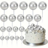 A set of twenty silver ball cake toppers on white sticks arranged in rows.