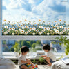 A close-up view of a window decorated with realistic daisy flowers, featuring a scenic landscape outside.