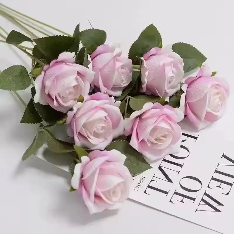 A bouquet of pink and white artificial roses on green leaves for weddings and home decor