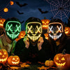 Three people wearing glow-in-the-dark LED purge masks for Halloween cosplay with carved pumpkin decorations in the background