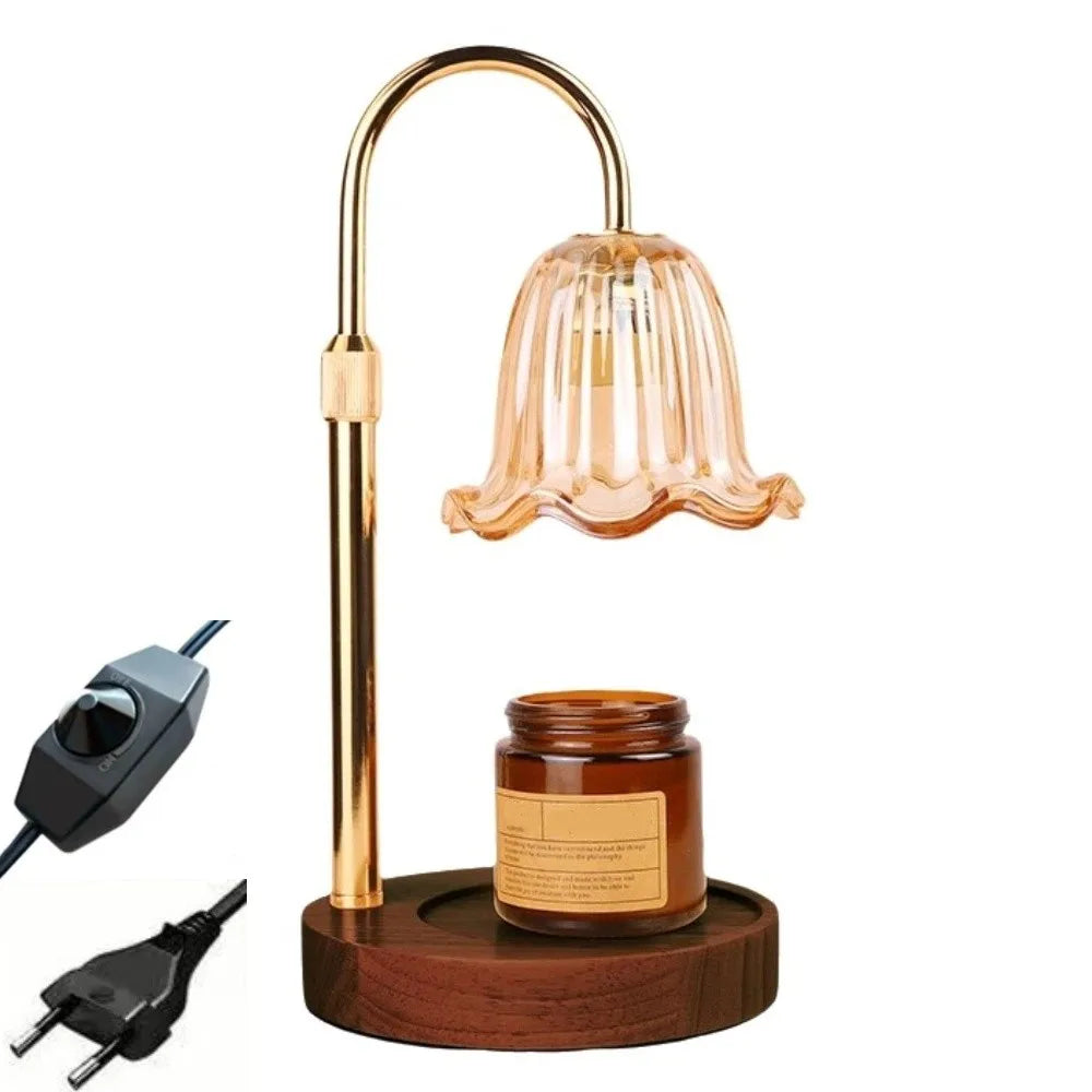 A gold-toned adjustable height aromatherapy candle warmer lamp with a glass shade and a wooden base.