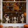 A window sticker featuring Halloween skulls and bats in black and white against a dark background.