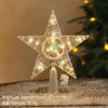 A clear, star-shaped LED Christmas tree topper with a warm white glow resting on a surface.