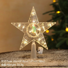 A clear, star-shaped LED Christmas tree topper with a warm white glow resting on a surface.