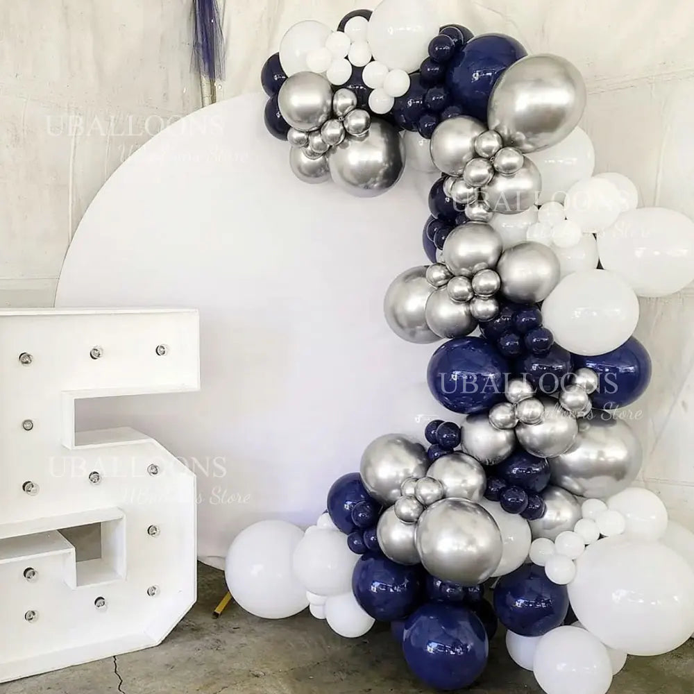 A large balloon garland featuring navy blue and silver balloons with metallic and pearl finishes.