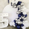 A large balloon garland featuring navy blue and silver balloons with metallic and pearl finishes.