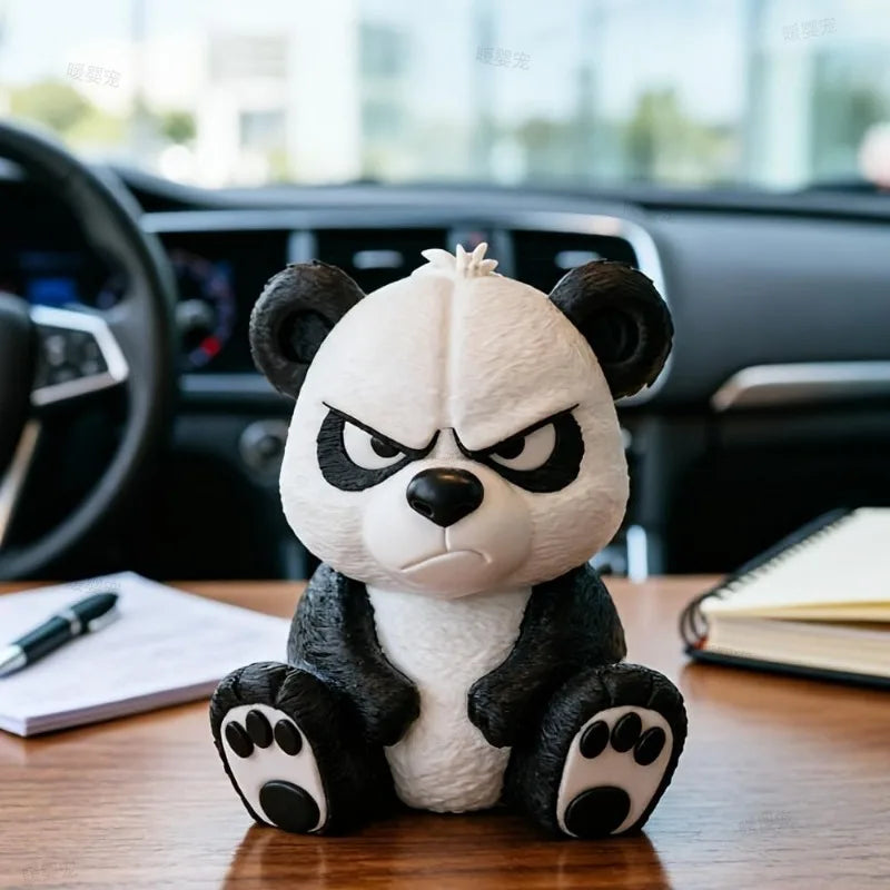 A cute angry panda figurine sitting on a wooden desk in front of a car dashboard.