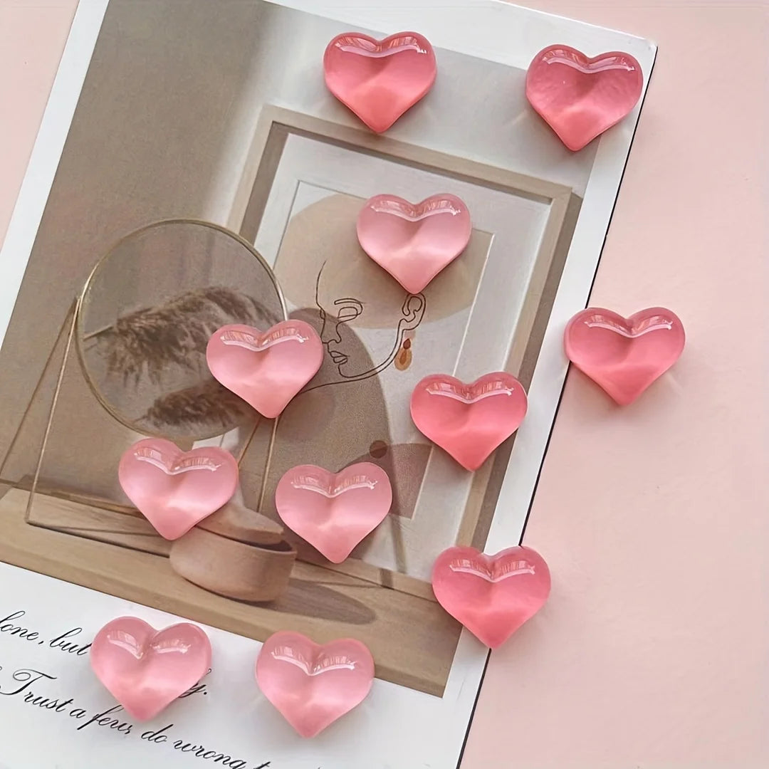 A set of ten pink heart-shaped resin refrigerator magnets displayed on a light pink background.