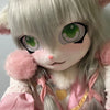 A light gray furry cosplay head with large green eyes and pink accents.