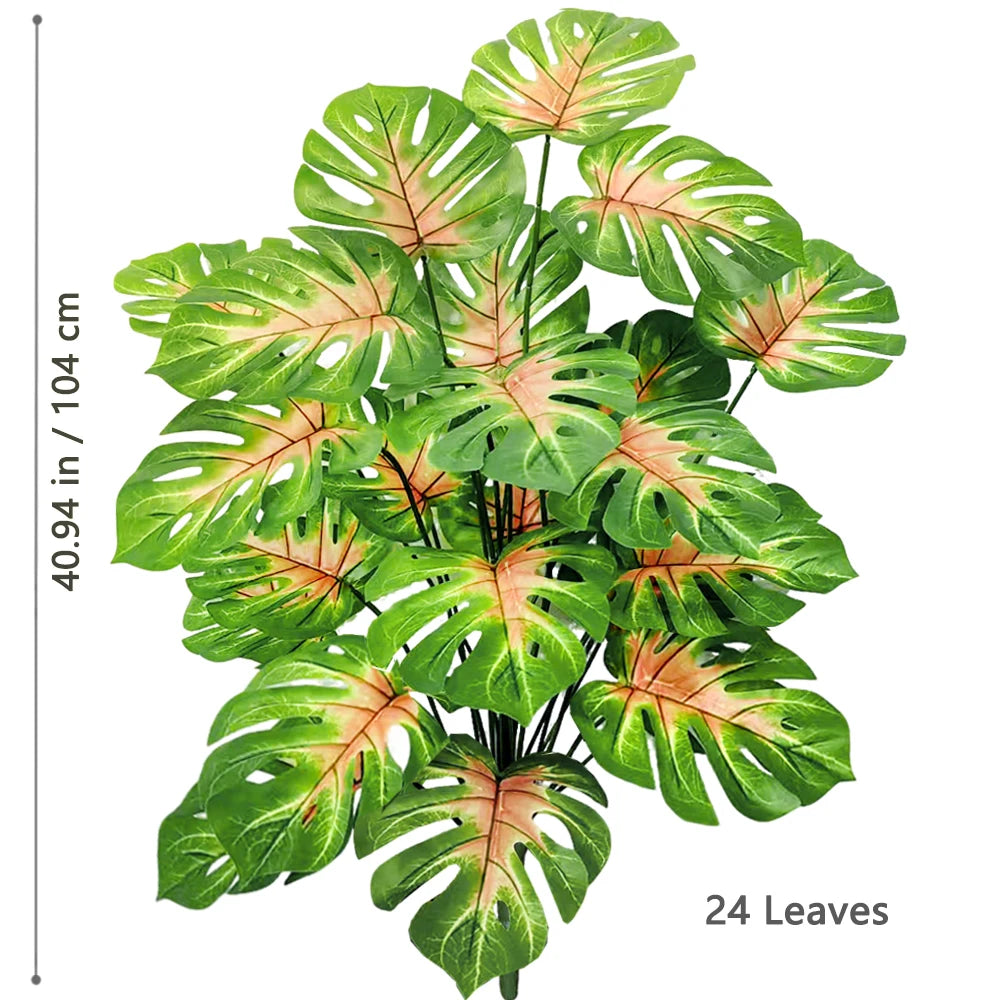 Artificial Monstera plant with silk green leaves displayed against a white background.