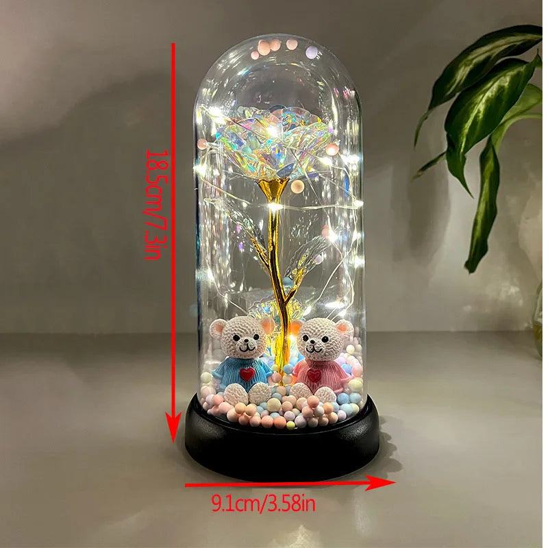 Una vitrina de vidrio con un árbol brillante y luces de colores y elementos decorativos pequeños.