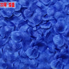 A close-up of vibrant blue silk rose petals scattered across a surface.