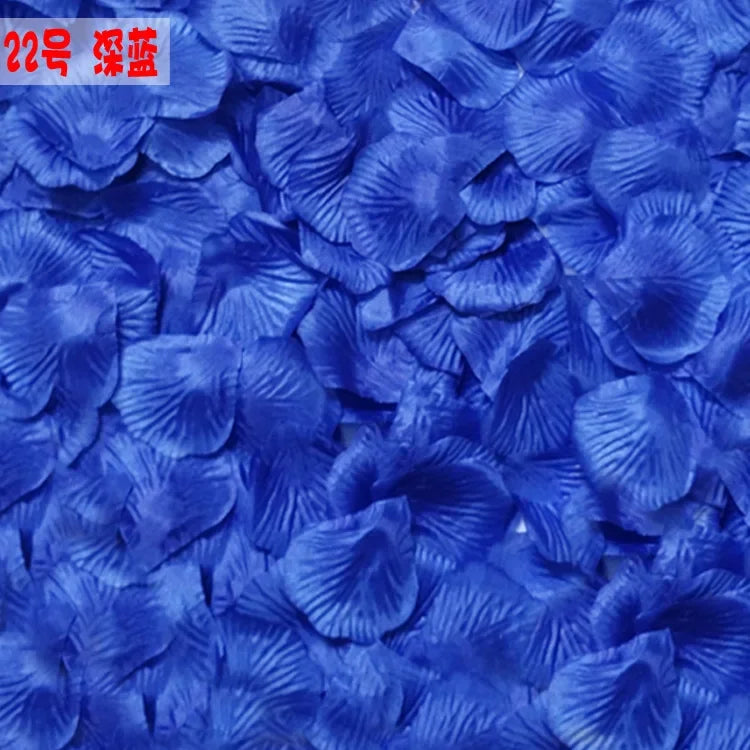 A close-up of vibrant blue silk rose petals scattered across a surface.