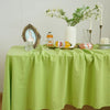 A lime green tablecloth set for a dining or event, featuring a floral arrangement and decorative items.