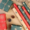 Rolls of festive Christmas kraft wrapping paper and red gift boxes with snowflake designs