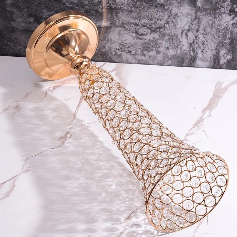 A gold crystal flower vase with a decorative gold finish is displayed on a white marble surface.