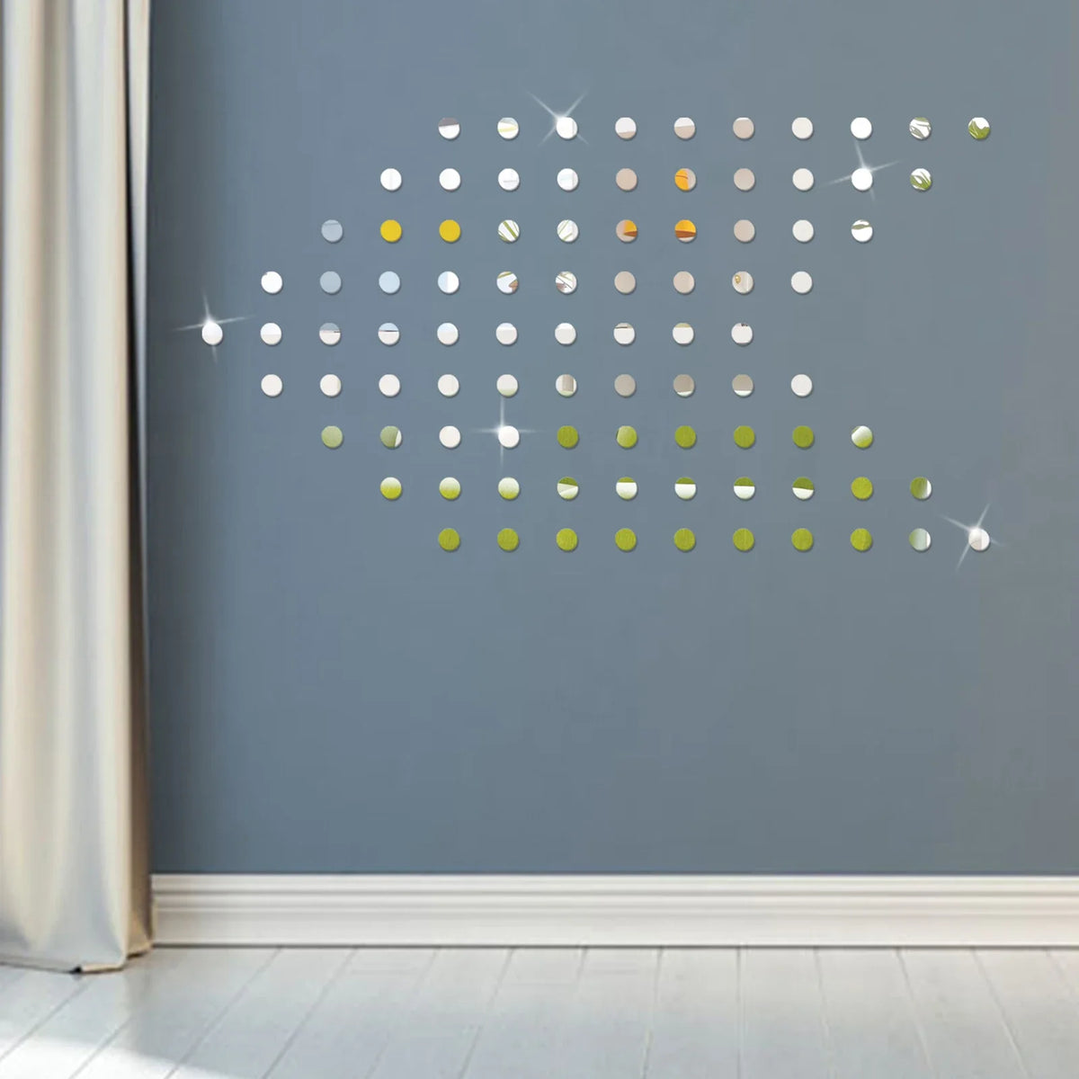 A gray wall decorated with a mosaic of small, reflective, circular mirror decals in various gold and silver tones.