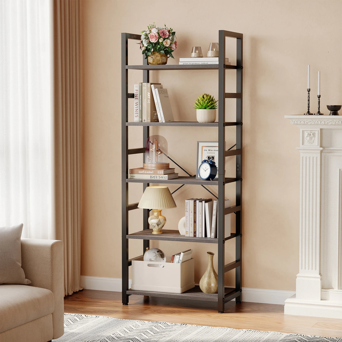 A tall, dark metal bookshelf with five tiers holds books, decorative items, and plants against a beige wall.