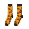 A pair of orange crew socks featuring repeating black tiger print patterns.