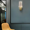 Modern bubble crystal LED wall sconces mounted on a gray wall above a tan chair.