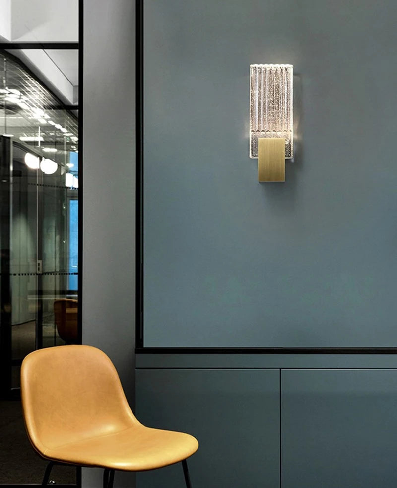 Modern bubble crystal LED wall sconces mounted on a gray wall above a tan chair.