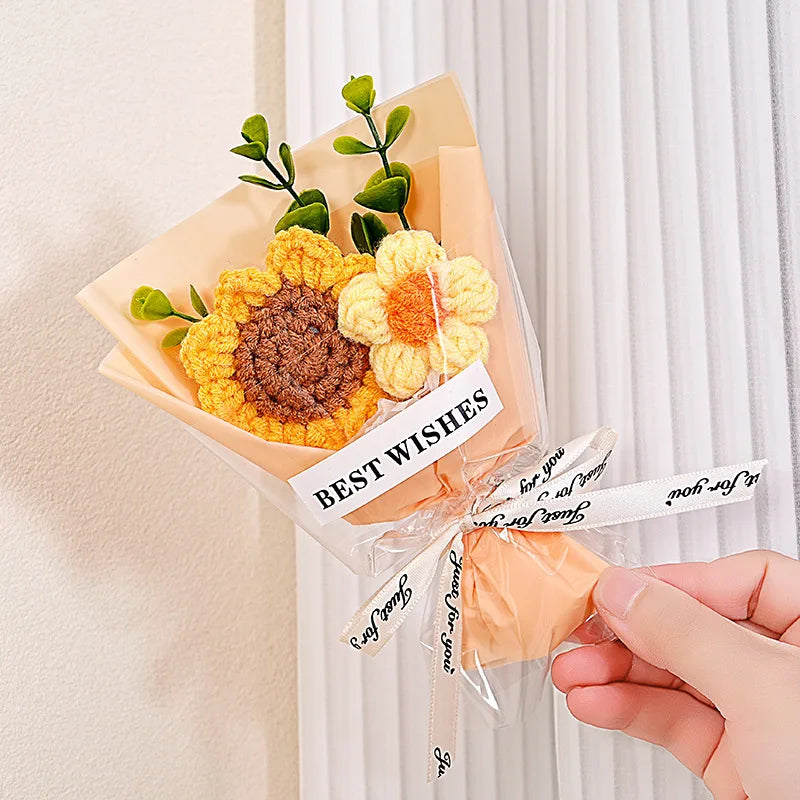 A handmade crochet flower bouquet featuring yellow and orange velvet blooms tied with a white ribbon for gifting