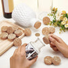 Hands are placing adhesive cork circles onto a white ceramic bottle and wooden board for crafting.