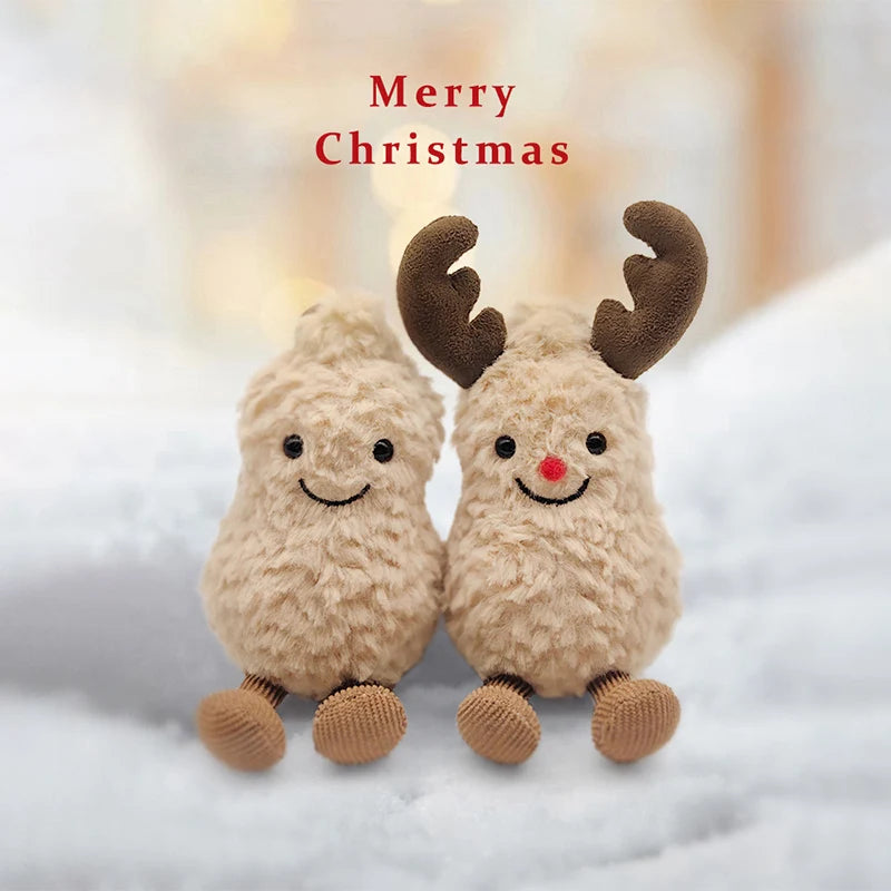 A pair of fluffy brown plush toys shaped like a peanut and reindeer with antlers resting on white snow.